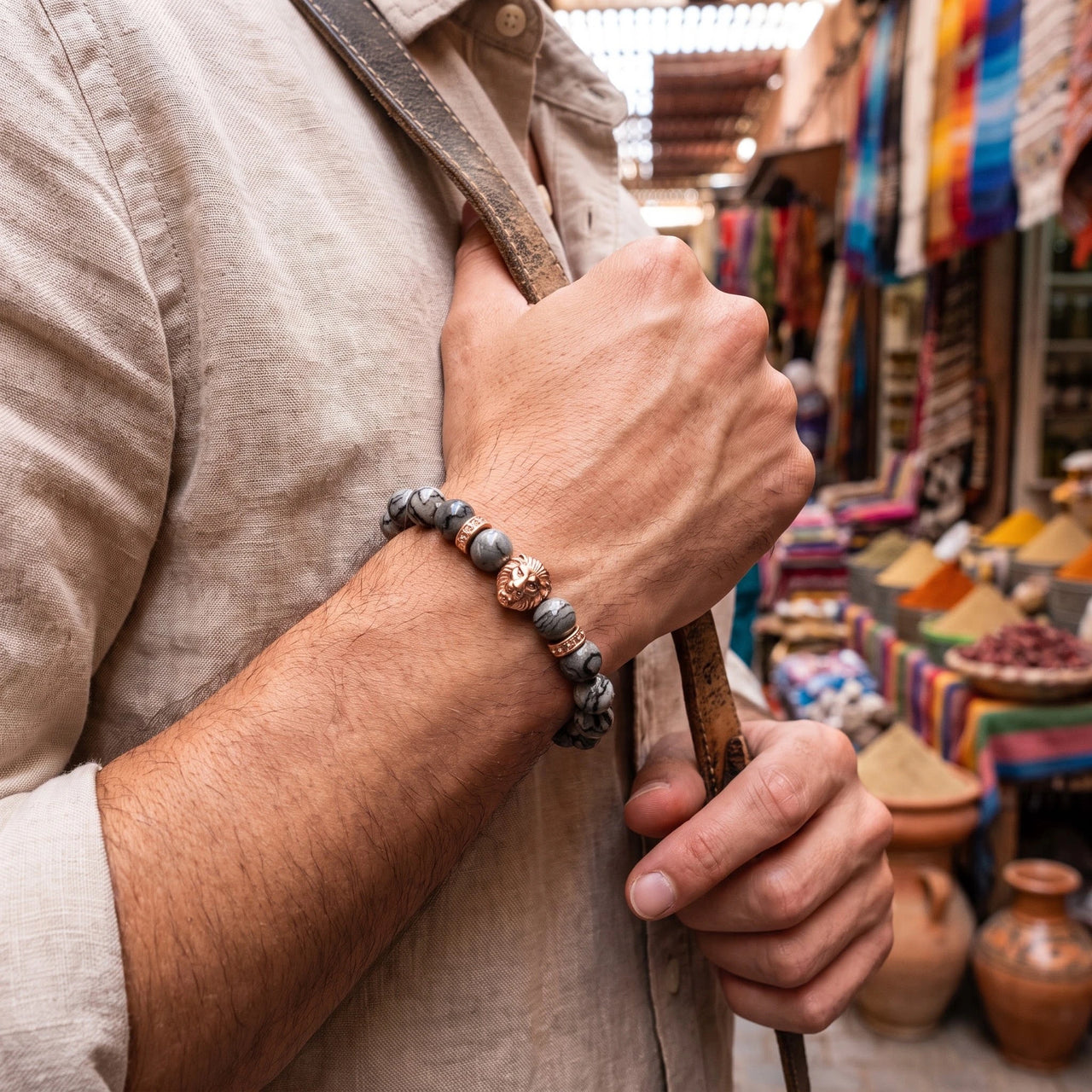 Rose Gold Lion & Grey Stones Bracelet – held in a man's hand | Brother & Sisters | SKU: 20866222-rose-gold-XS-14-15, 20866222-rose-gold-S-16-17, 20866222-rose-gold-M-18-19, 20866222-rose-gold-L-20-21, 20866222-rose-gold-XL-22-23