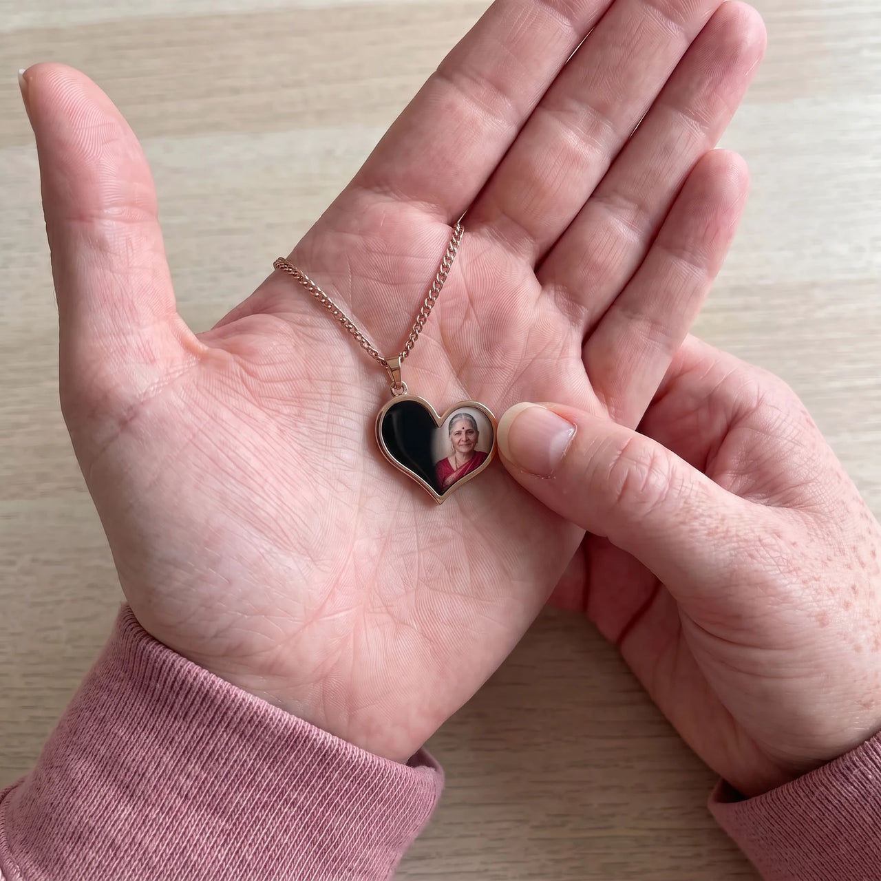 Thumb warming the rose gold heart pendant: the hidden photo appears under the thumb while the rest stays black | SKU: TPH-HRTN-ROSEGOLD